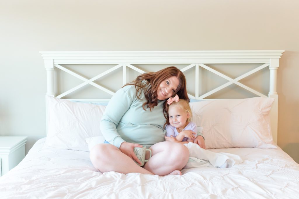mom posing with toddler daughter on bed branding photos for Golden Heart photography Anne Haug