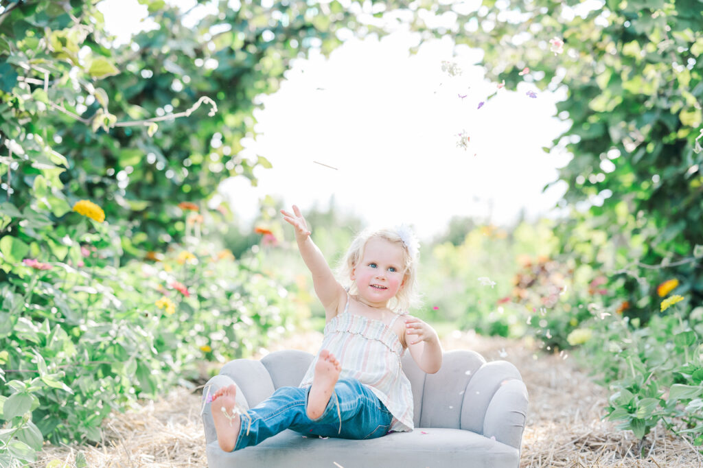 toddler throws flowers at Pretty Bird Farm Mommy & Me Family Session by Golden Heart Photography Flemington NJ Family Photographer