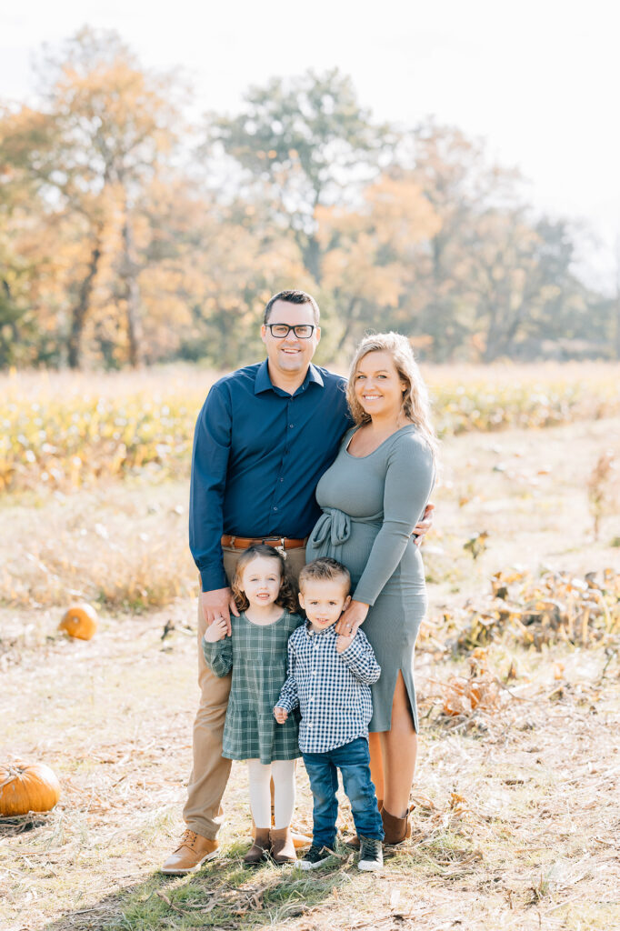 Flemington Fall Mini Session | Maternity Photoshoot NJ | The D'Angiolillo Family family of four in coordinating blues and teals in pumpkin patch