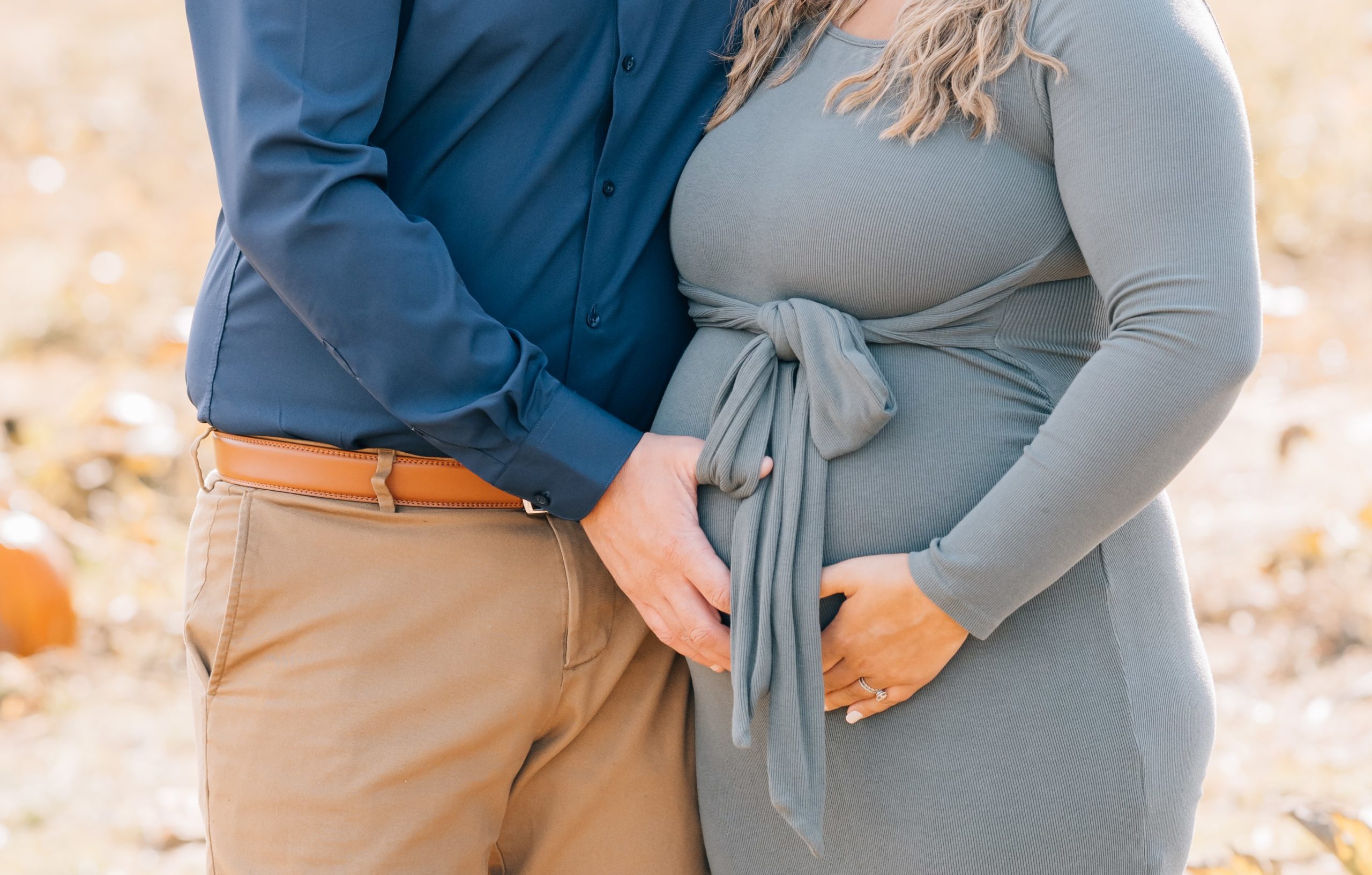 mom and dad hands on baby bump at fall mini session with Golden Heart Photography