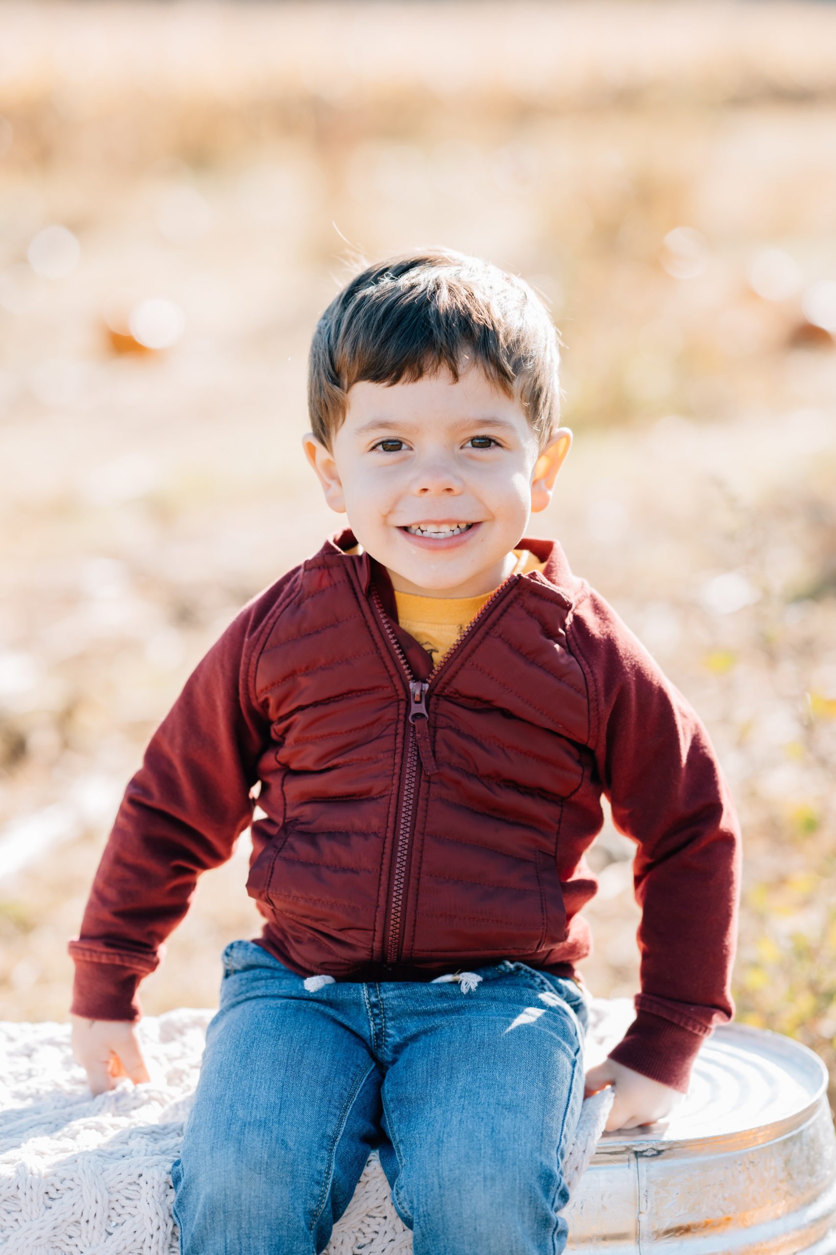 toddler boy poses at fall family session with Golden Heart Photography
