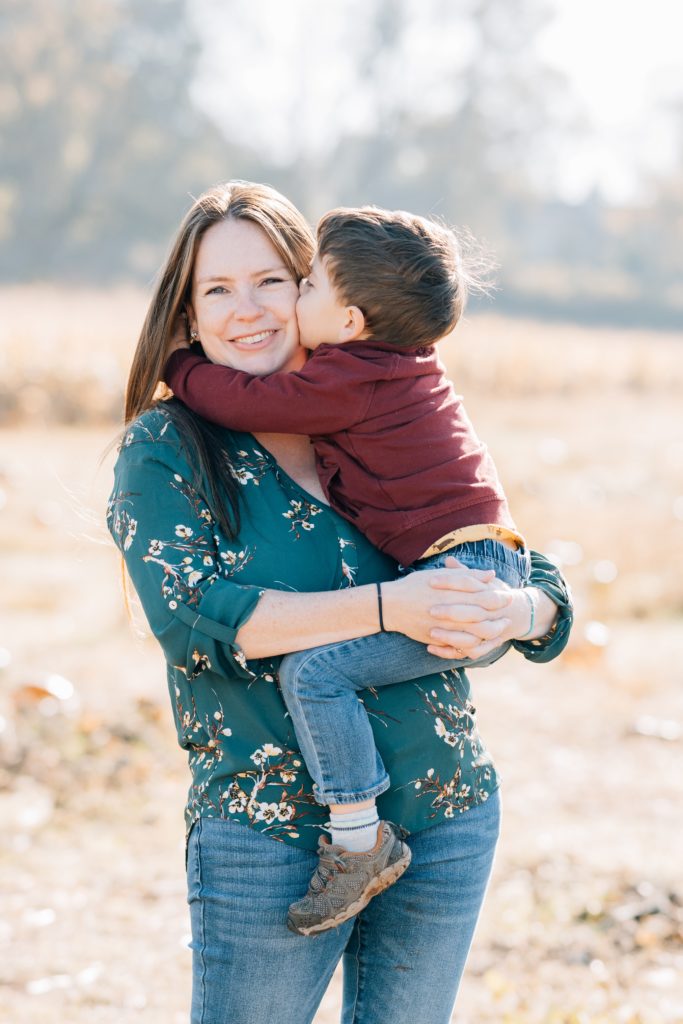 toddler boy kisses mom at fall family session with Golden Heart Photography