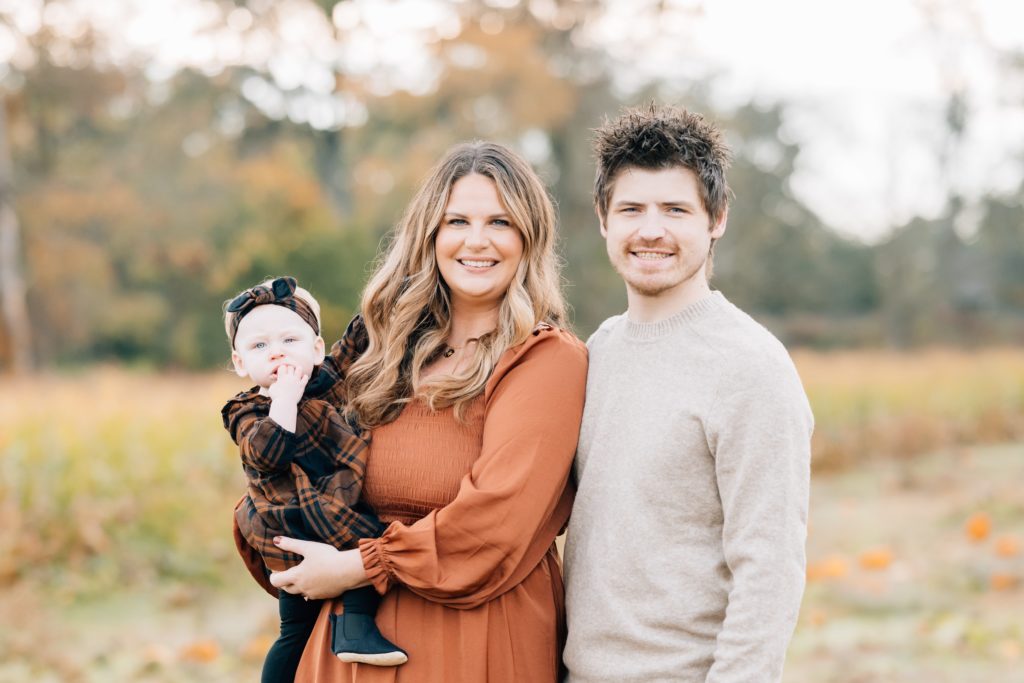 family of three mom and dad pose with baby girl at session with Golden Heart Photography Flemington Fall Mini Session | New Jersey Portrait Photographer | The Newman Family