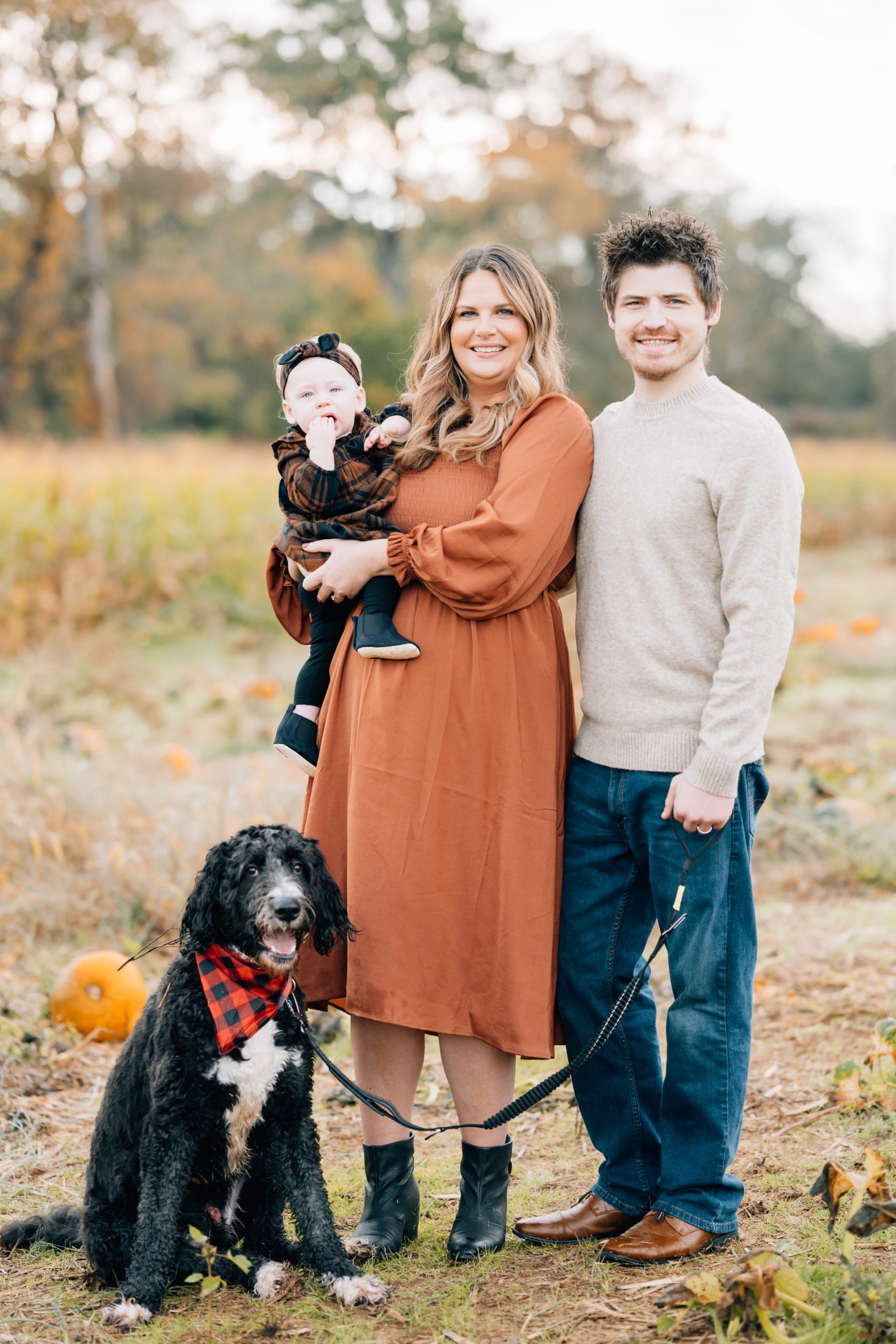family poses with dog at mini session with Golden Heart Photography