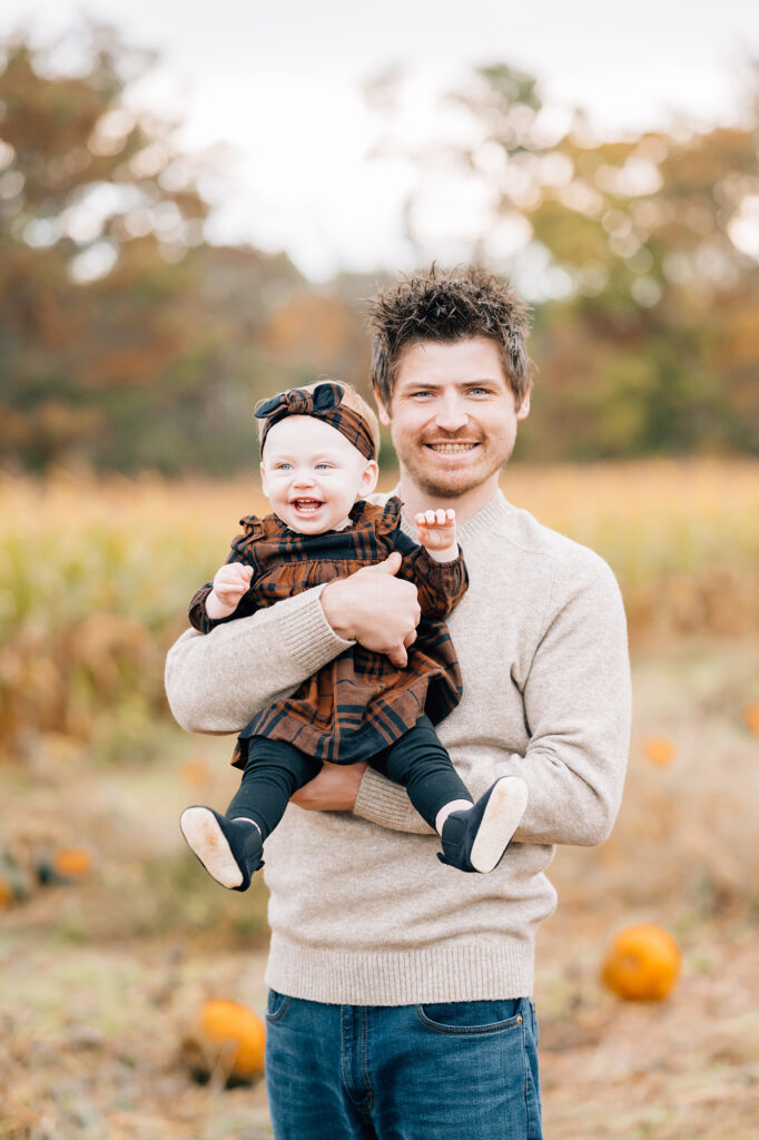dad poses with baby girl at fall mini session with Golden Heart Photography