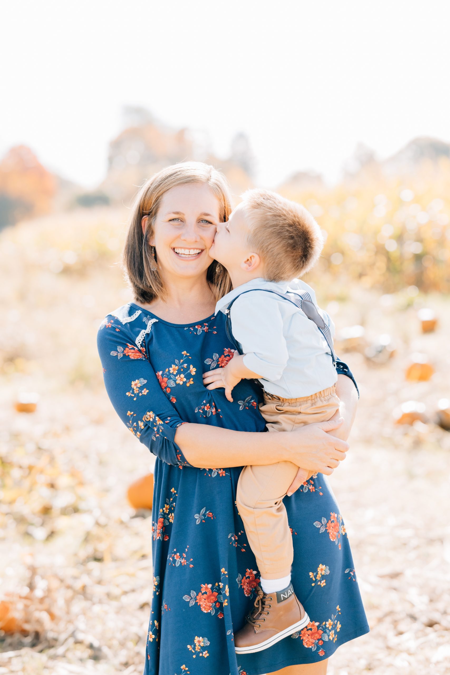 toddler boy kisses mom on cheek at fall mini session with Golden Heart Photography
