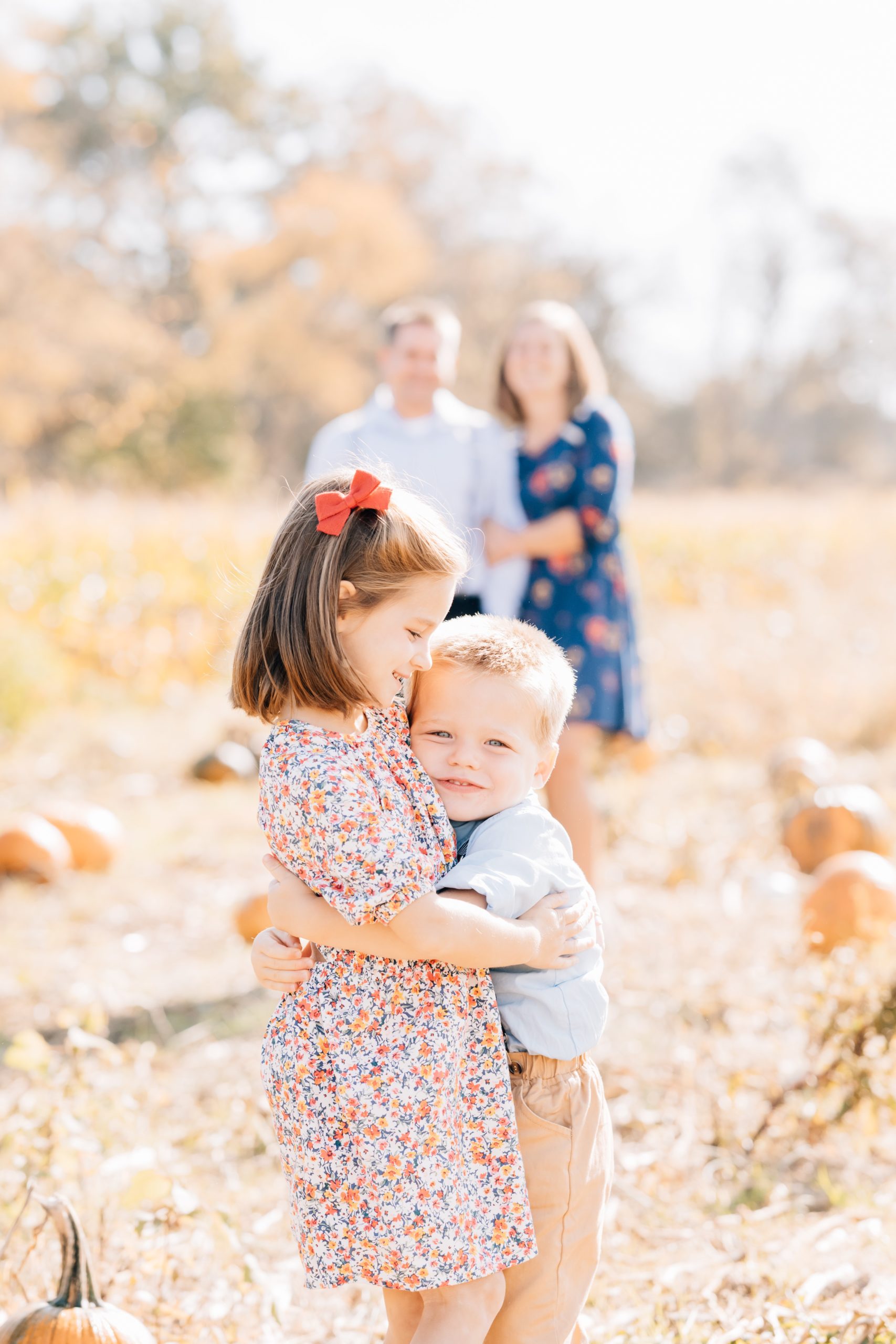 brother and sister hug in foreground with mom and dad in background Flemington Fall Mini Session | The Demetriou Family