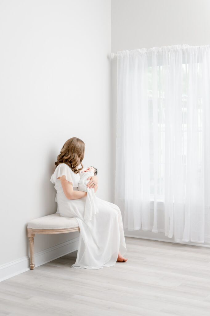 mom with baby girl in client wardrobe studio newborn session