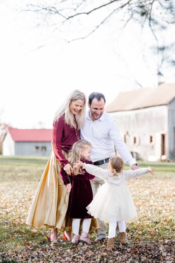 girls run and give hugs to mom and dad Holiday Mini Session | Five Birds Farm Ringoes | The Munz Family | Golden Heart Photography
