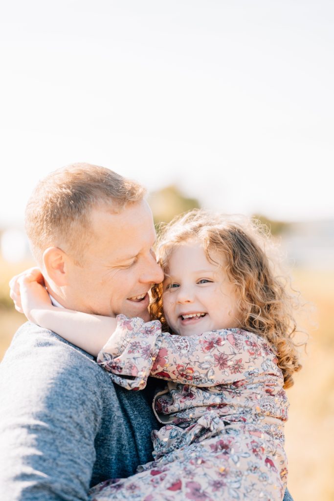 dad and daughter give big hugs at mini session with Golden Heart Photography