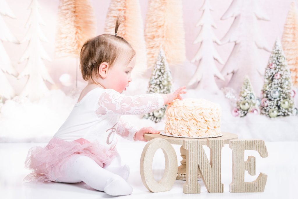 sweet girl enjoys her cake at cake smash session with Golden Heart Photography 