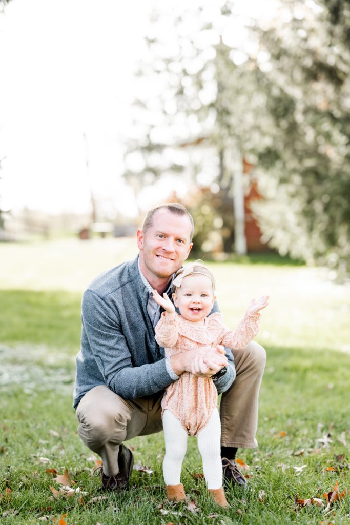 dad poses with clapping happy baby in soft pink Holiday Mini Session | Hunterdon County Mini Sessions | The Furstenburg Family | Golden Heart Photography