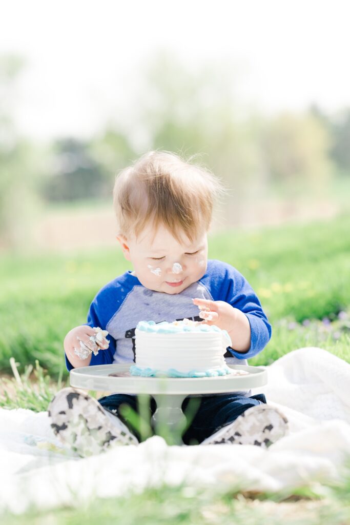 toddler boy enjoys cake smash with Golden Heart Photography