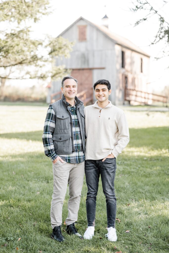 father and son pose with barn in background at rustic farmstead with Golden Heart Photography